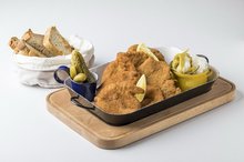 Mix of chicken and pork schnitzels, gherkin, pickled hot pepper, bread from our oven