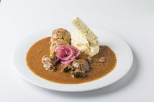Traditional Czech beef goulash with red onion, bread and bacon dumpling
